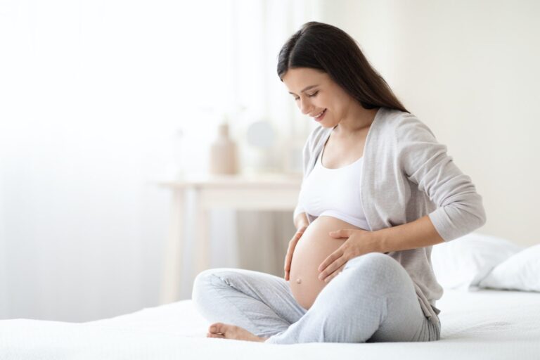 smiling-pregnant-woman-sitting-on-bed-in-her-bedroom-768x512 Cairns Acupuncture (new)